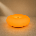 Lexion Orbit glowing ring table lamp on a premium warm studio background